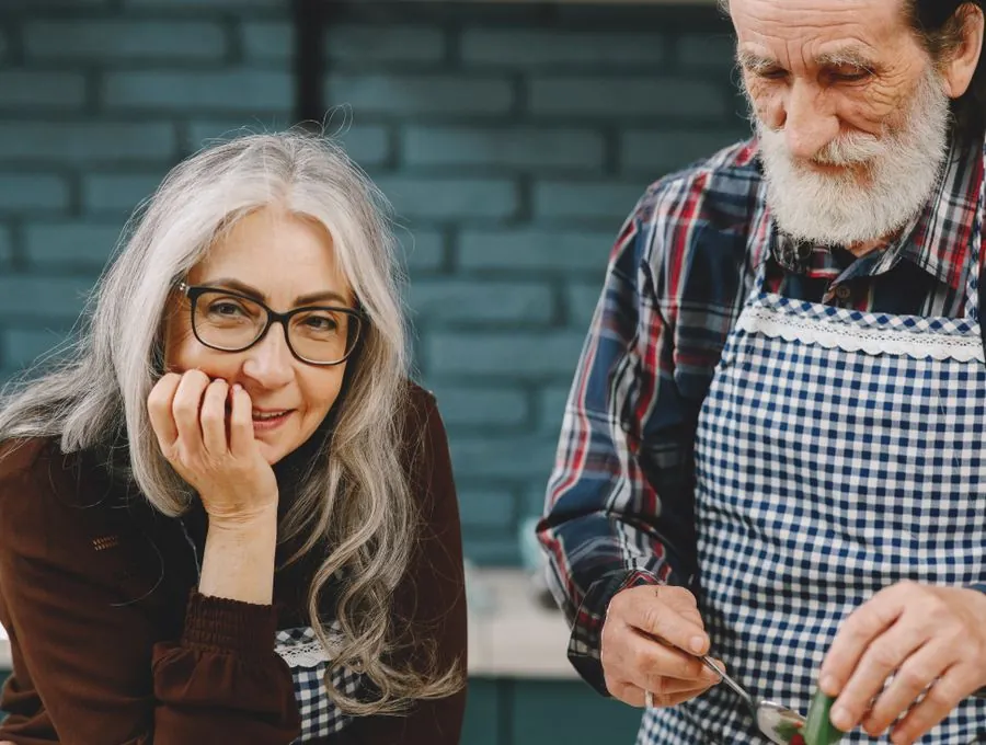 A senior couple preparing a meal together in their kitchen.