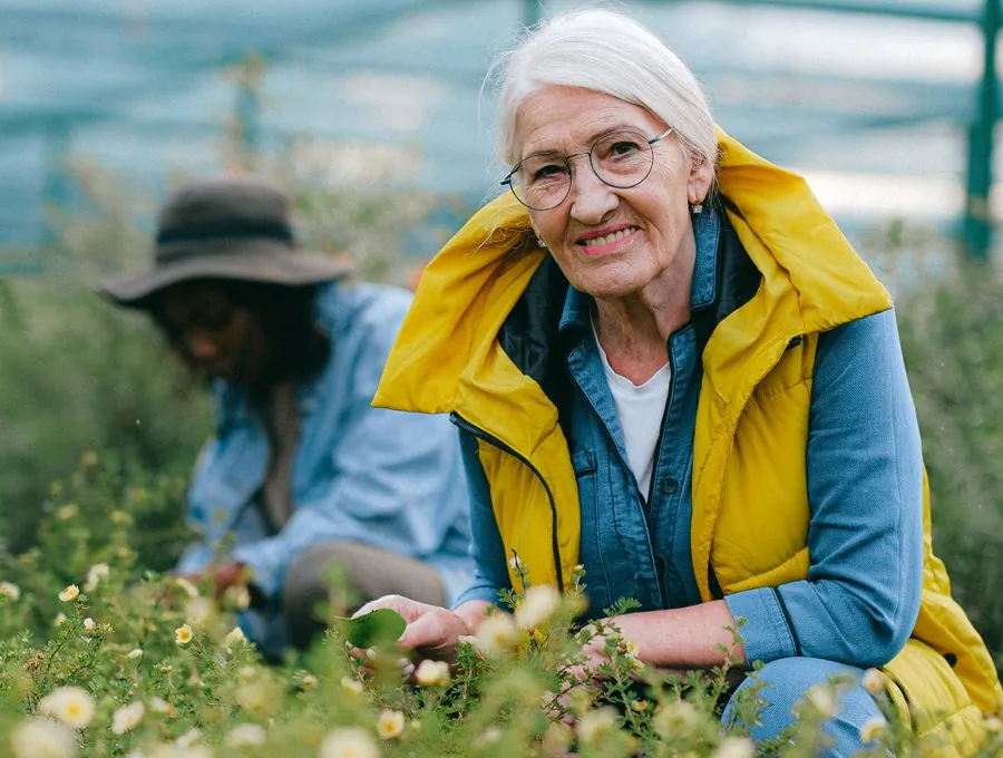 A smiling senior woman enjoying time outdoors in a garden.