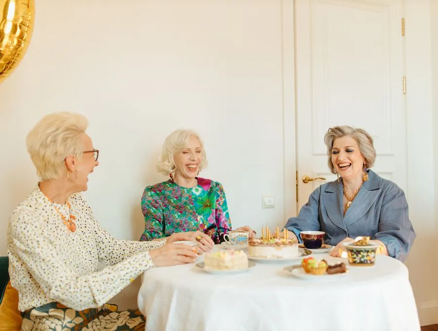 Older friends laughing together over afternoon tea.